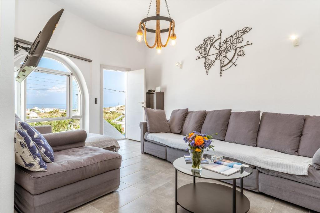 a living room with a couch and a table at Sunset Horizon Villa in Mikonos