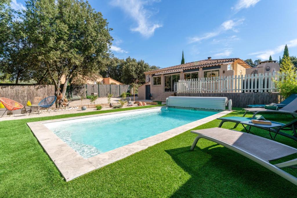 a backyard with a swimming pool and a house at La Petite Maison in Bédoin