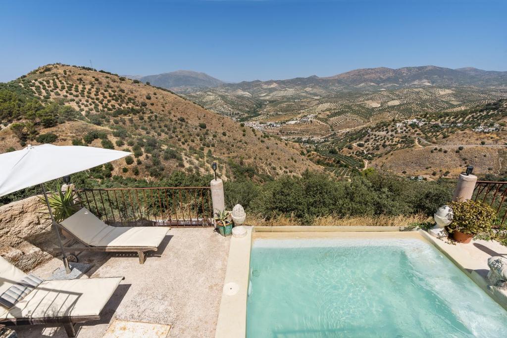 a swimming pool with a view of a mountain at Casa Rural Ermita de las eras in Algarinejo
