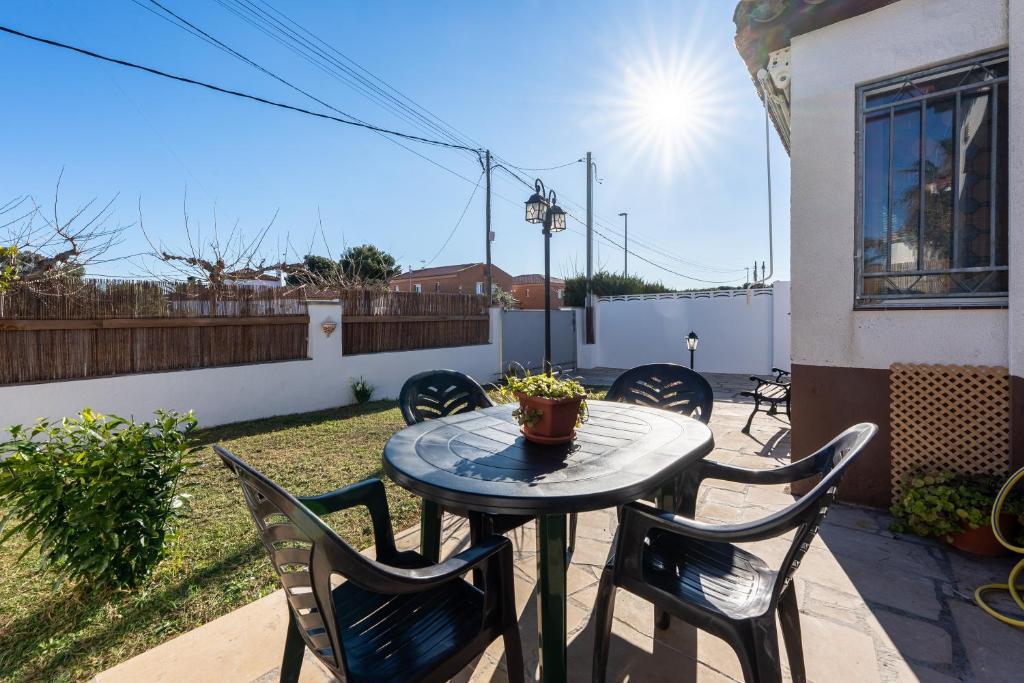 a patio table with chairs and a plant on it at Casa Thaiker in Miami Platja
