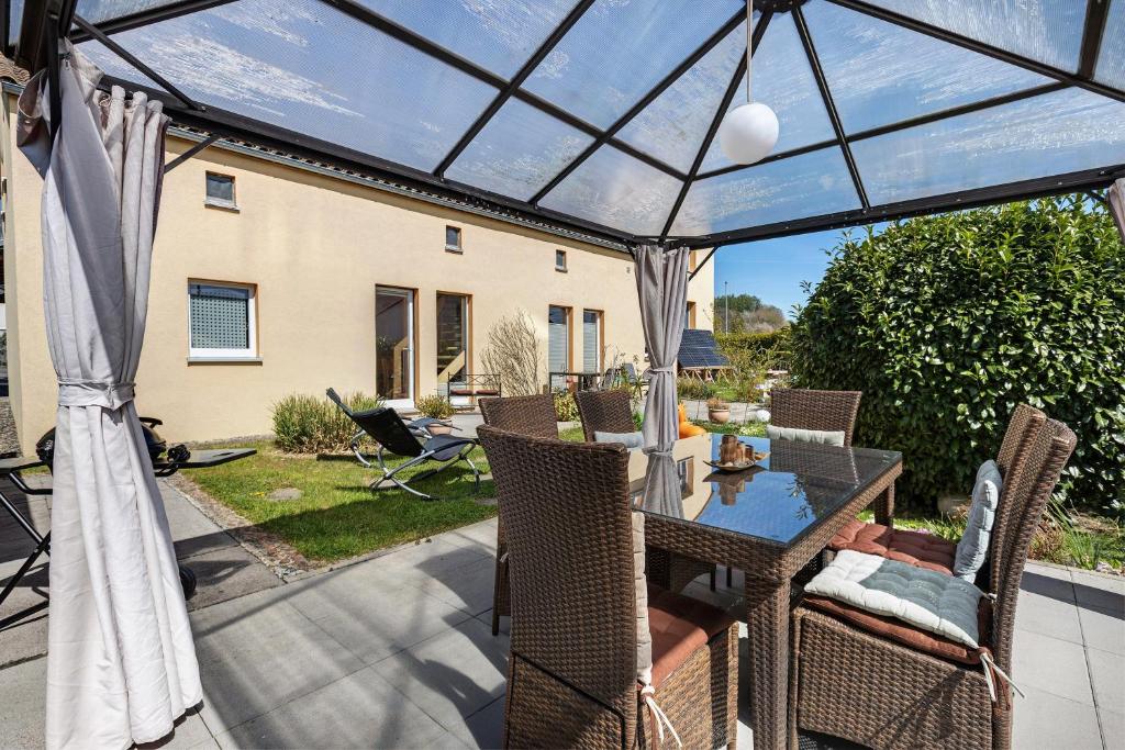 a patio with a glass roof over a table and chairs at Ferienwohnung Beni in Öhningen