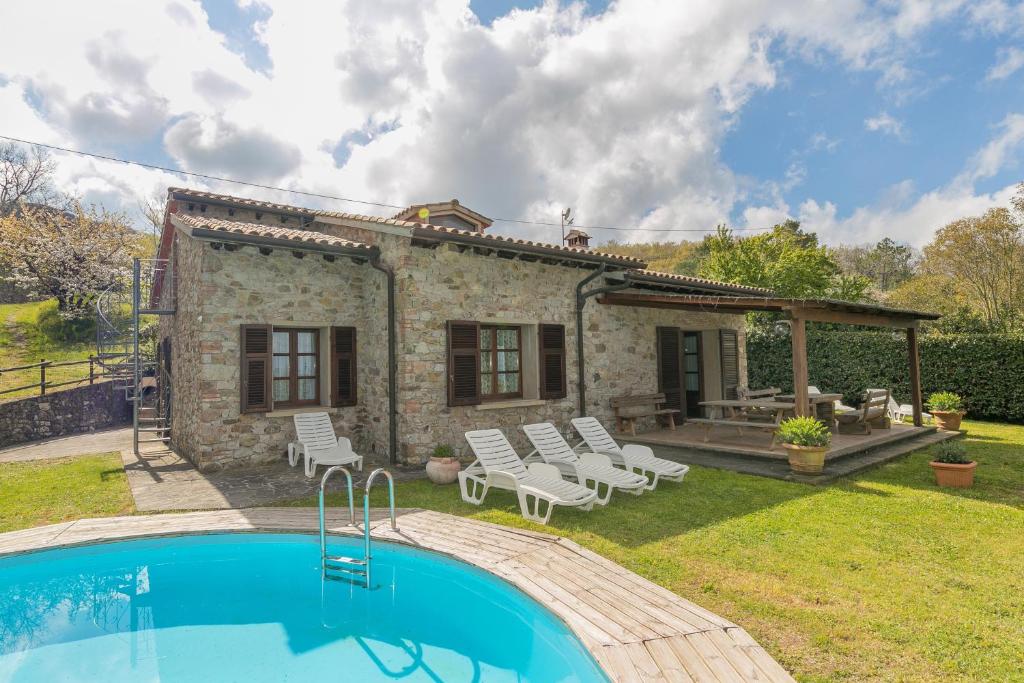 a house with a swimming pool in the yard at Stupendo rustico in pietra in Castellina Marittima