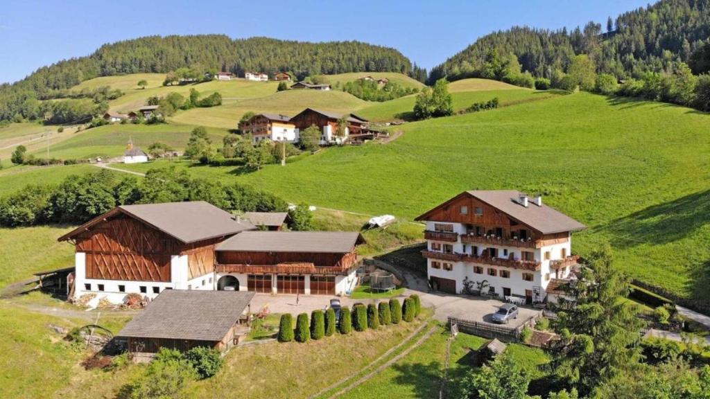 an aerial view of a house in a green field at Veltierhof Villnöß in Funes
