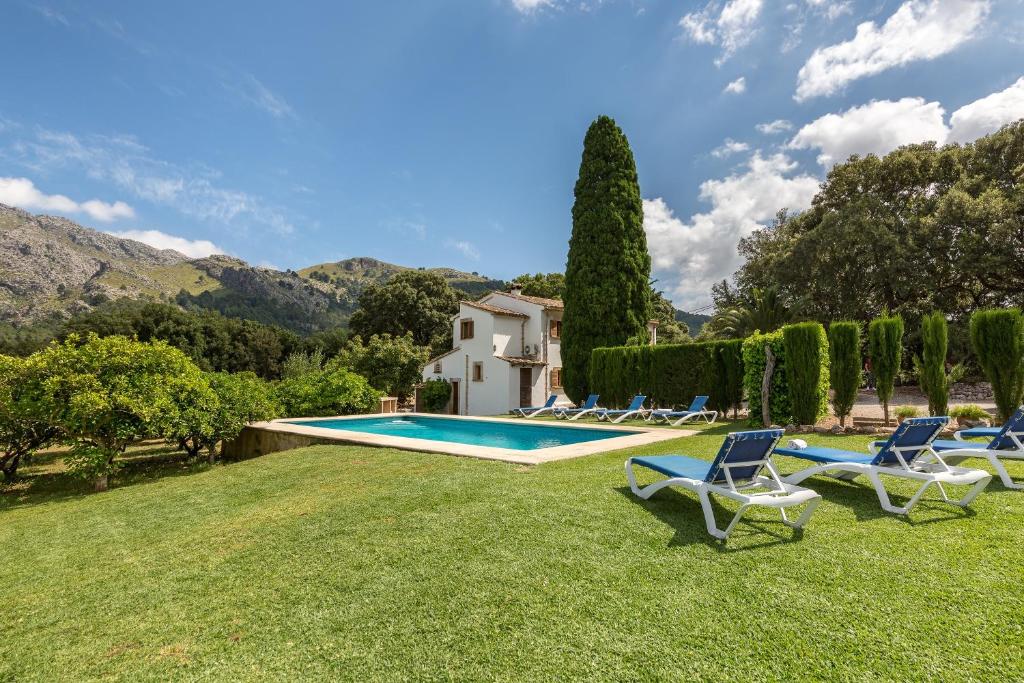 a yard with chairs and a swimming pool at Villa La Plana in Pollença