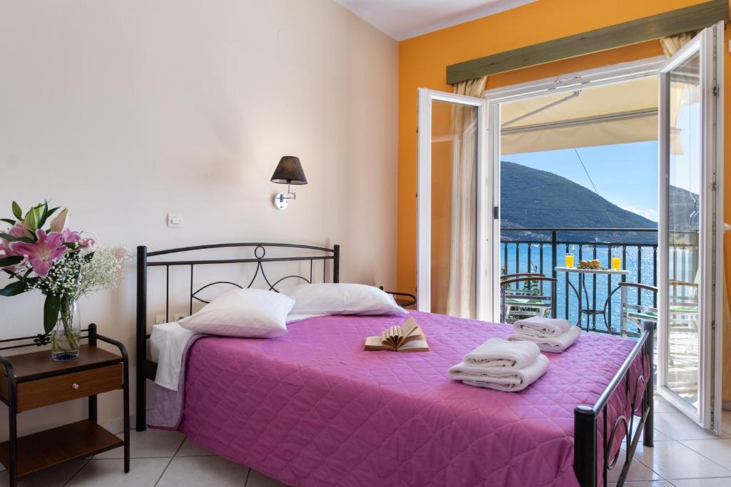a bedroom with a purple bed with towels on it at Apostolos Apartment 3 in Póndi