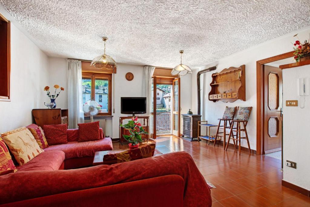 a living room with red couches and a tv at Casa Lella Clemy in Aymavilles