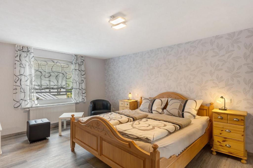 a bedroom with a bed and a desk and a window at Ferienwohnung Christel in Schmallenberg
