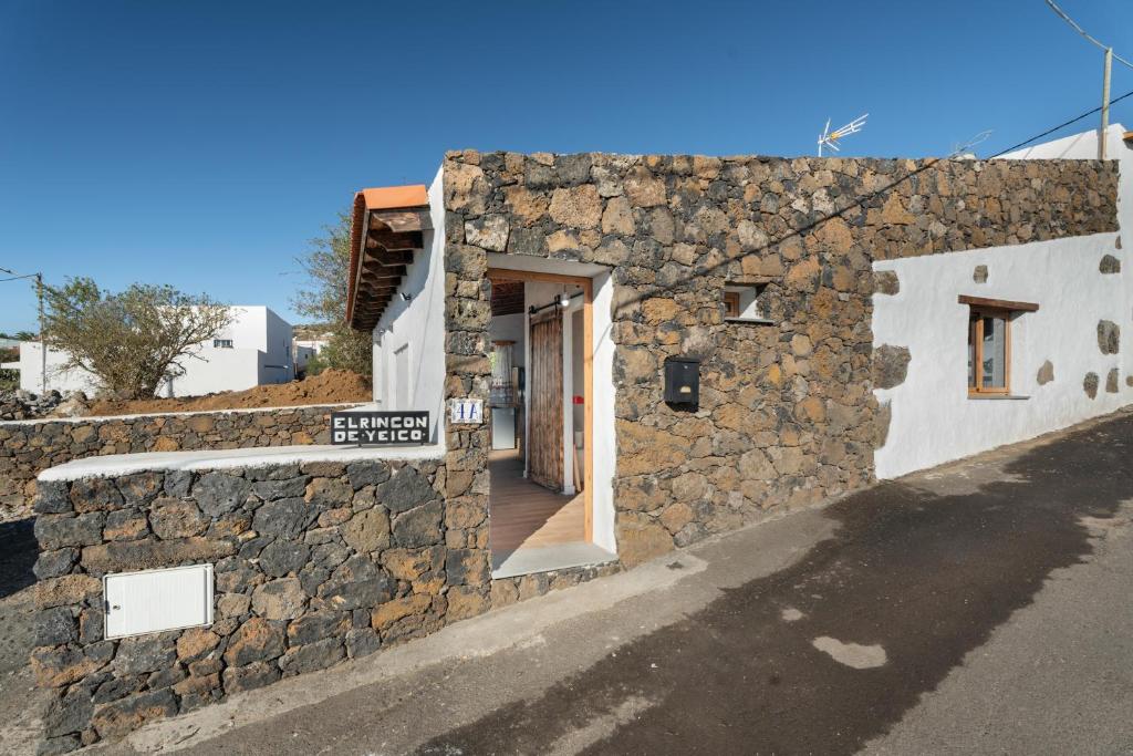 a stone building with a door on a street at El Rincón de Yeico in Isora