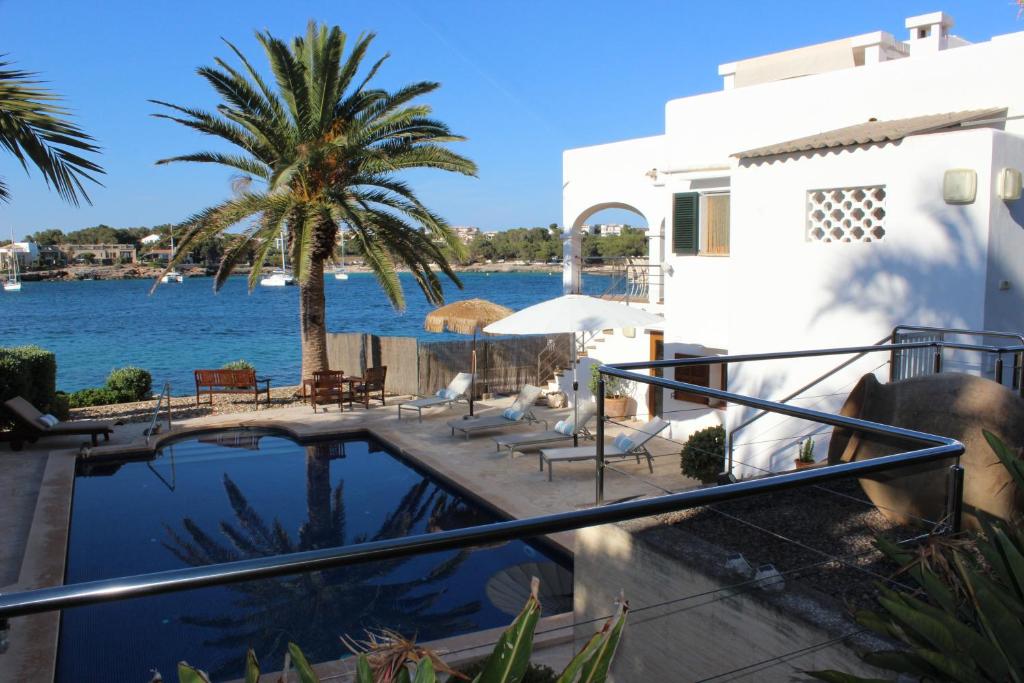 a house with a swimming pool next to the water at Casa Vora Mar in Felanitx