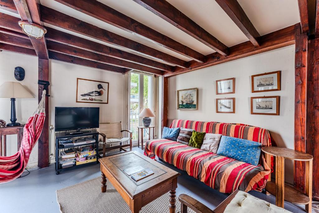 a living room with a couch and a tv at Loft familial Arcachon in Arcachon