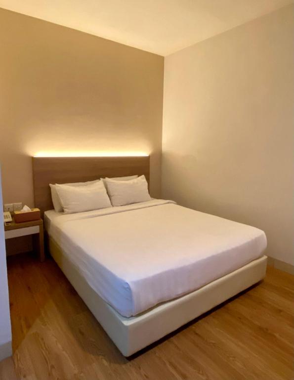 a bedroom with a white bed in a room at Lovina Inn - Nagoya Batam in Nagoya