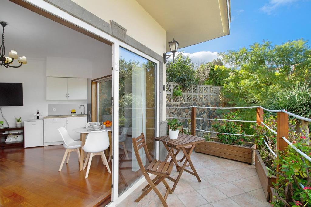 a kitchen and dining room with a balcony with a table and chairs at Carmelo y Carmela 2 in Teror