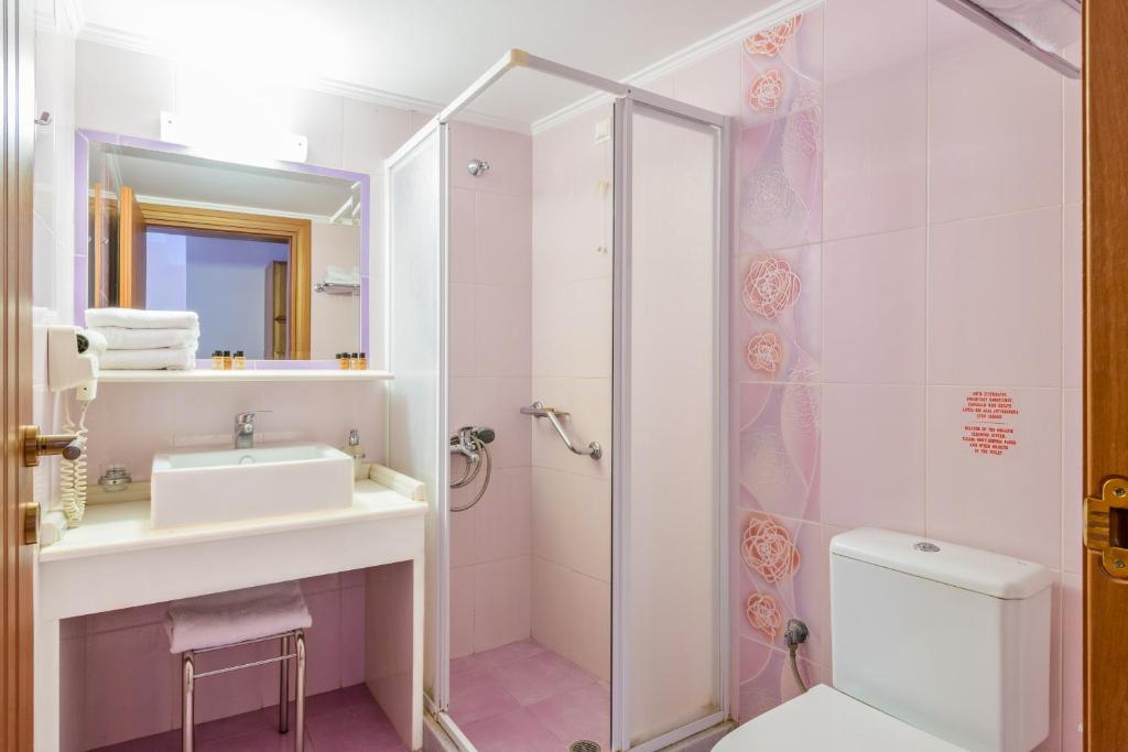 W łazience znajduje się prysznic, umywalka i toaleta. w obiekcie Akrata Beach Hotel w mieście Akrata
