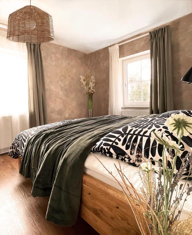 a bedroom with a bed with a blanket and a window at Haus Silberberg in Haslach im Kinzigtal