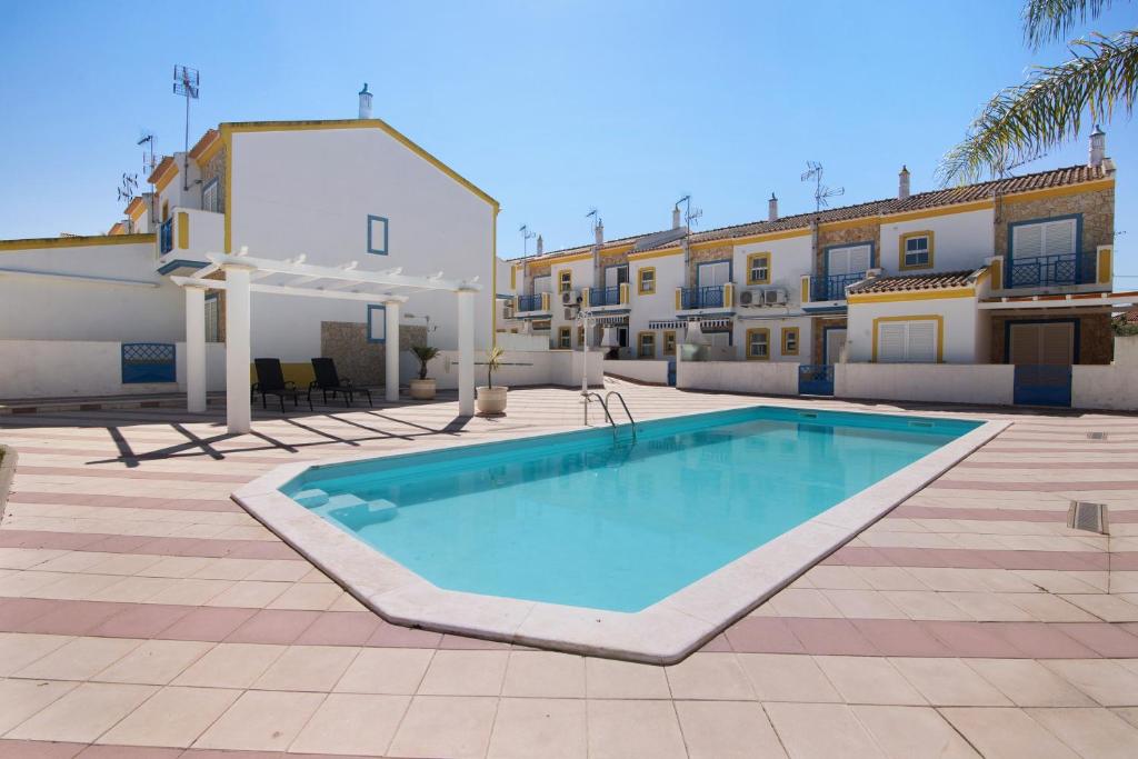 a large swimming pool in front of a building at Villa Constança in Manta Rota