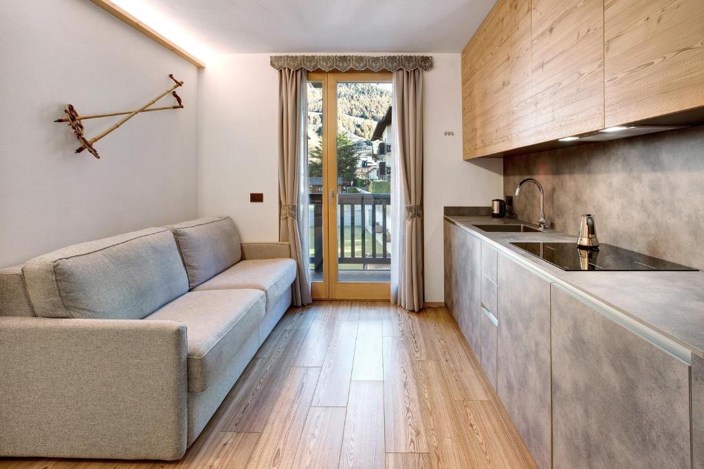 a living room with a couch and a kitchen at Olympic Chalet 11 in Bormio