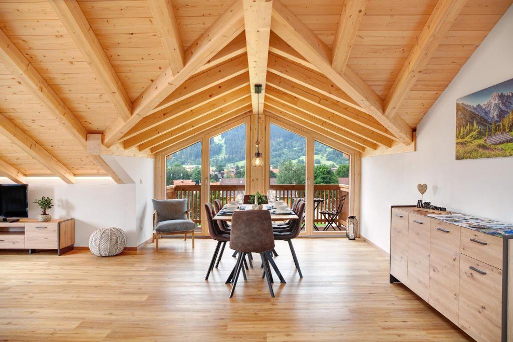 a dining room with wooden ceilings and a table and chairs at Alpenloft Meditz in Unterammergau