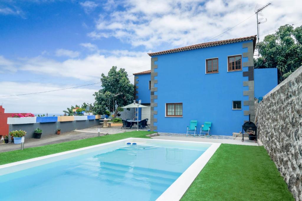 a villa with a swimming pool in front of a house at Casa Las Cañas in Icod de los Vinos