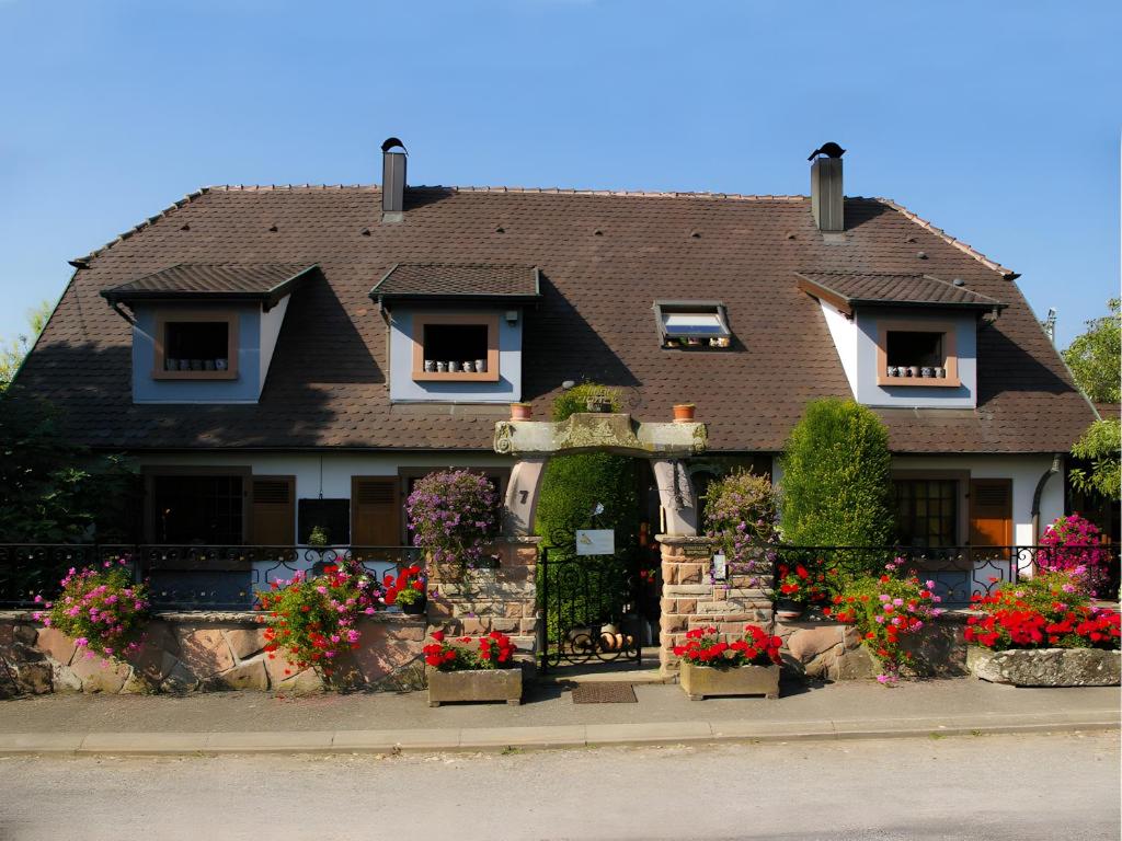 a large house with flowers in front of it at Gîte Éclat De Soleil in Beblenheim