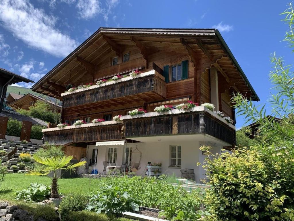 a house with a balcony with flowers on it at Apartment Chalet Nussknacker by Interhome in Lenk