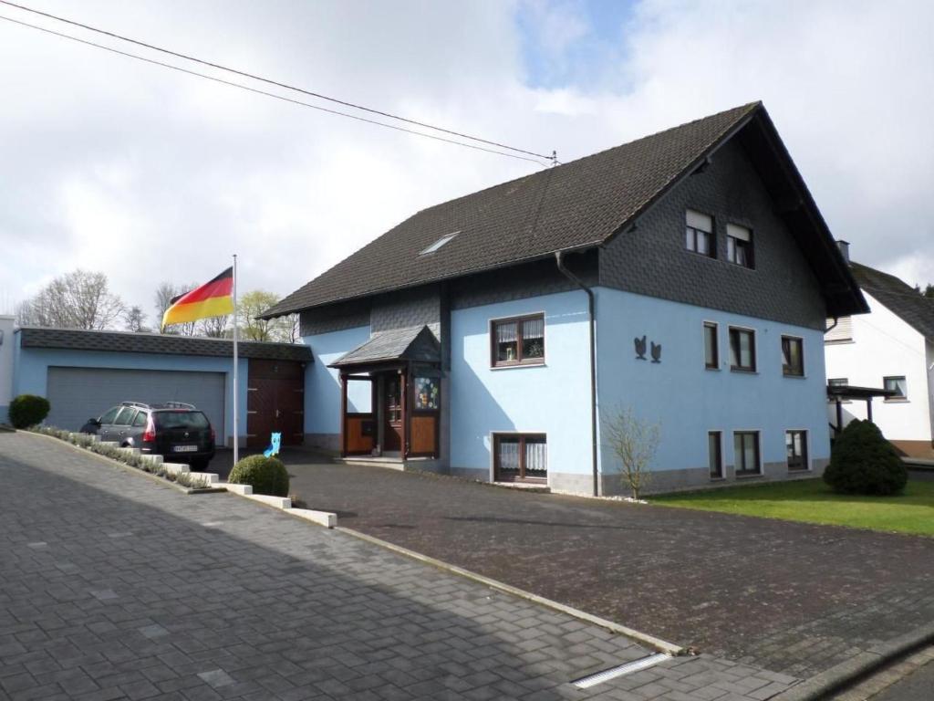 a white house with a black roof on a street at Apartment Orpington by Interhome in Dreisbach
