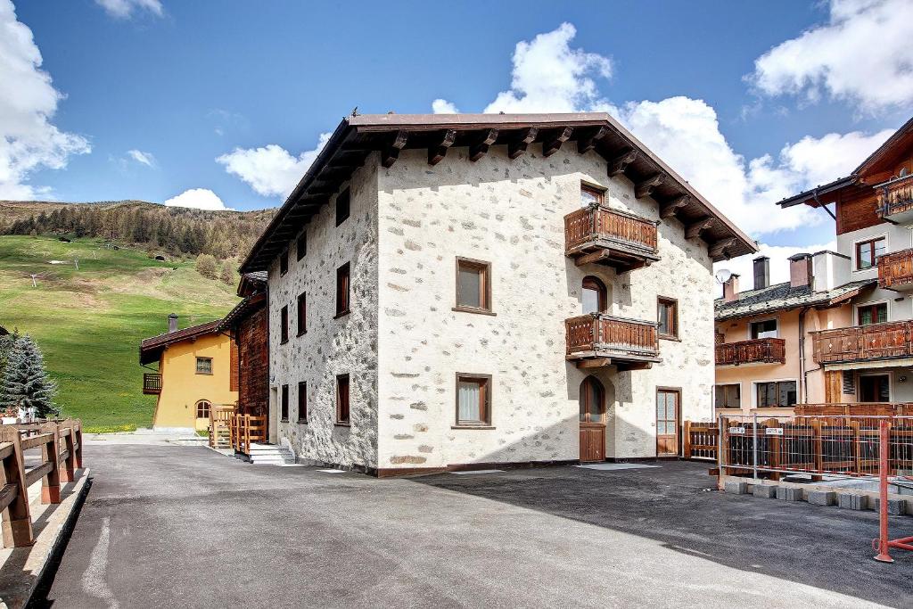 a large white building with a hill in the background at Appartamenti Elisabetta n2 in Livigno