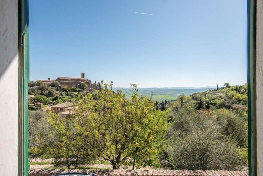 a view from a window of a hill with trees and houses at Casa Francesca in Montalcino