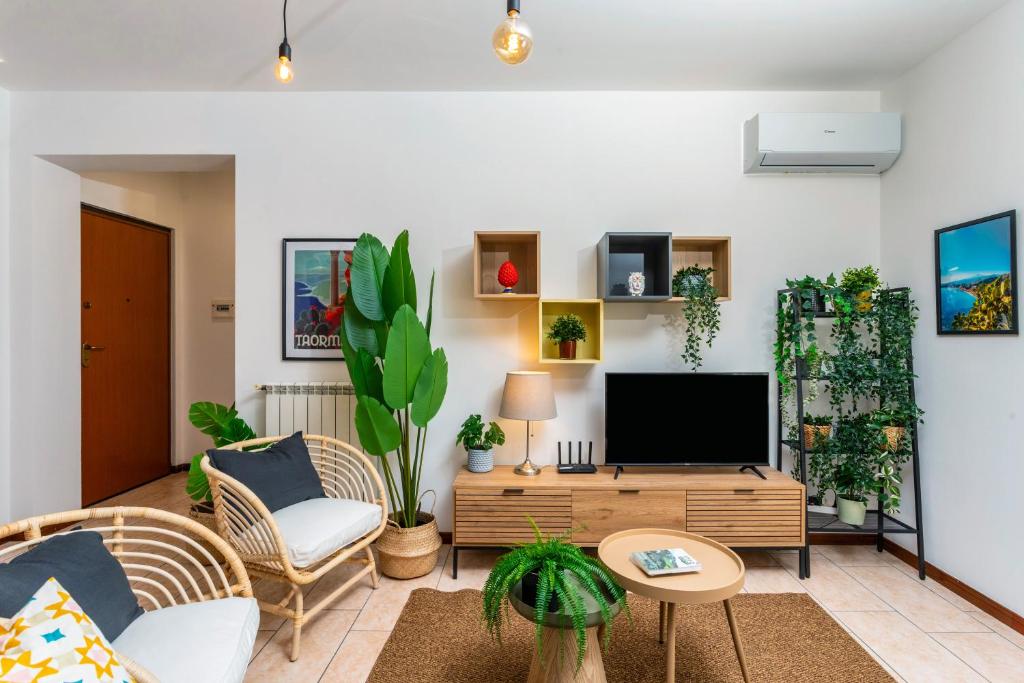 a living room with a tv and some plants at Home Centrum 2 in Giarre