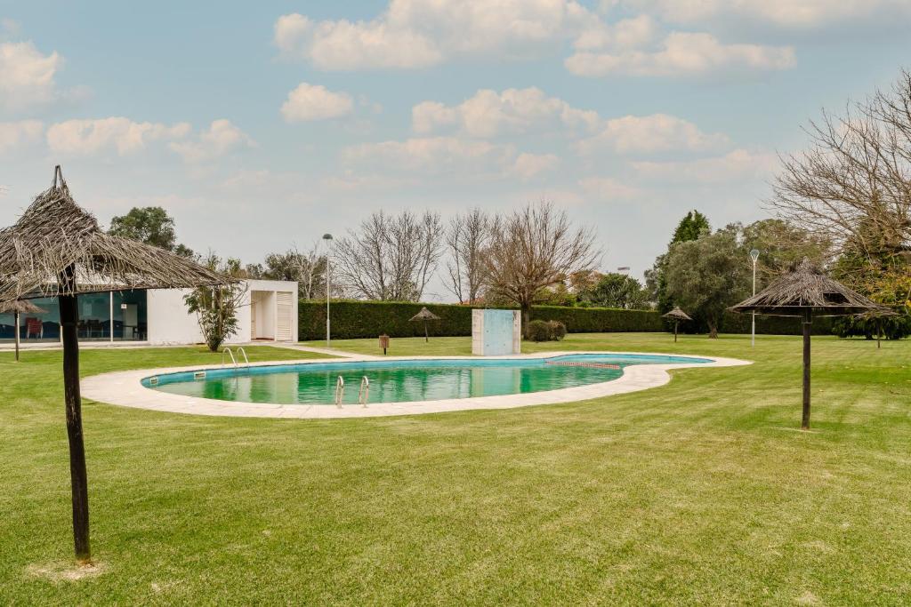a swimming pool in a yard with umbrellas at Paradise Villa in Esposende