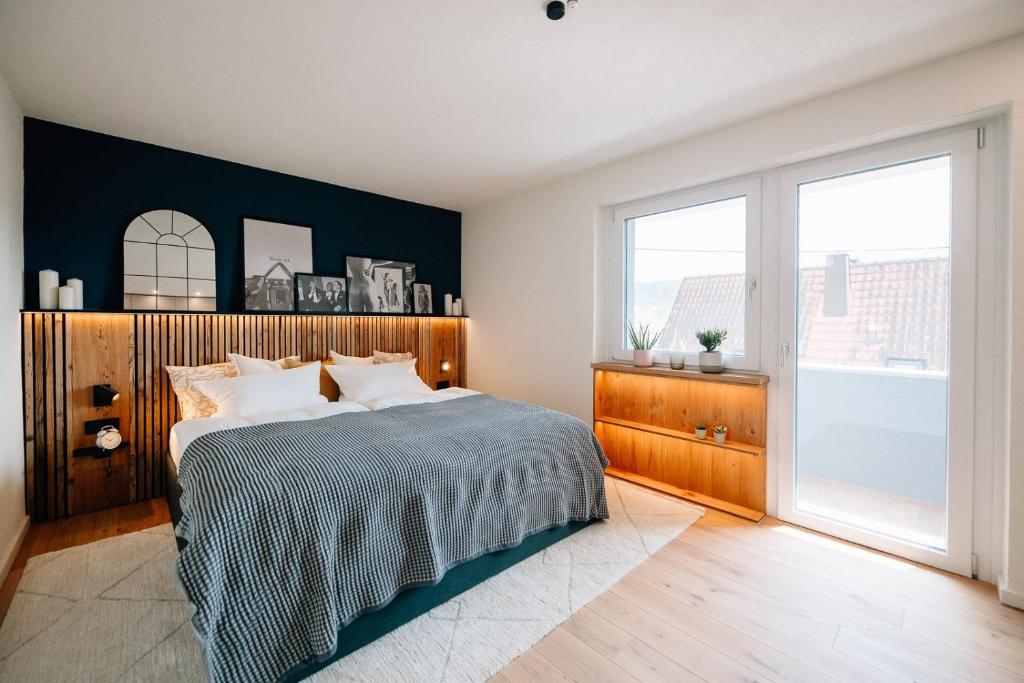 a bedroom with a bed and a large window at Fewo Tauberblick in Röttingen