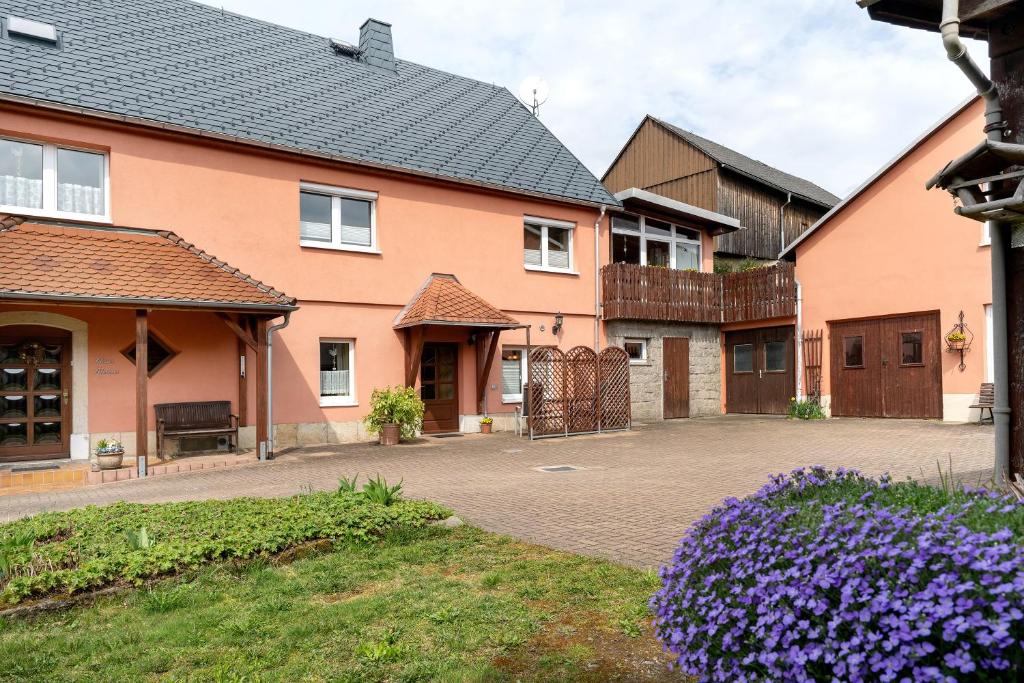 a house with a courtyard with purple flowers at Ferienwohnung Ahrens in Ehrenberg