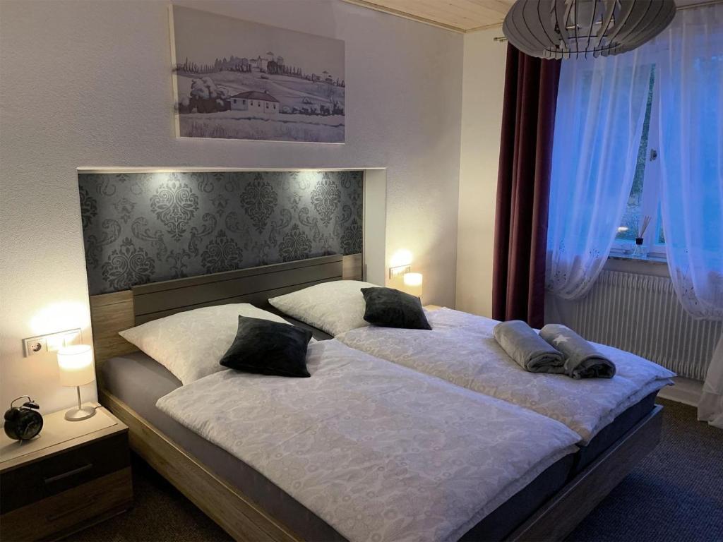 a bedroom with a large bed with two pillows at Ferienwohnung Bullentäle in Albstadt