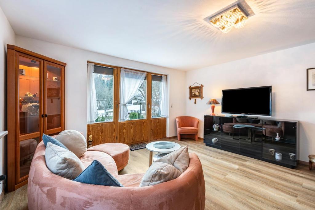 a living room with a couch and a tv at Am Wehrastrand App Eg in Todtmoos