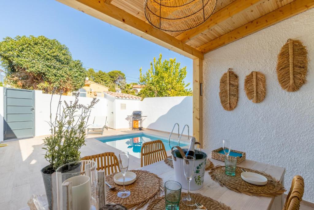 a patio with a table and chairs and a swimming pool at El Pinito Moraira in Moraira