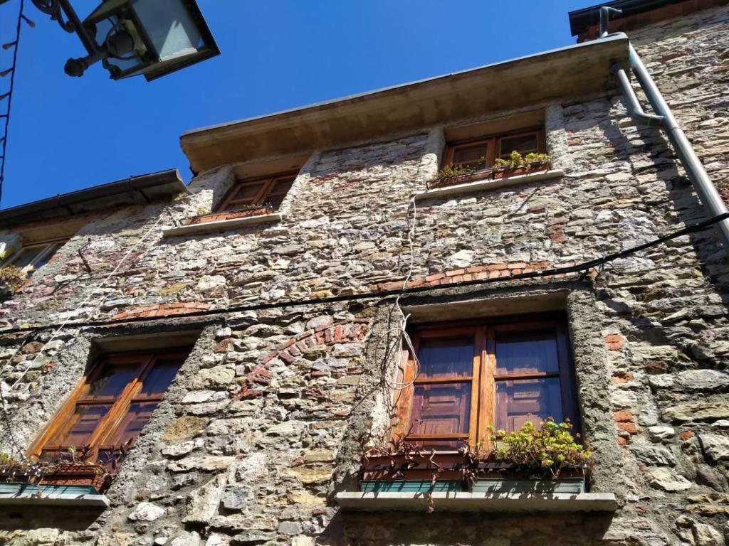 an old stone building with windows and flower boxes at Casa Annamaria in Arcola