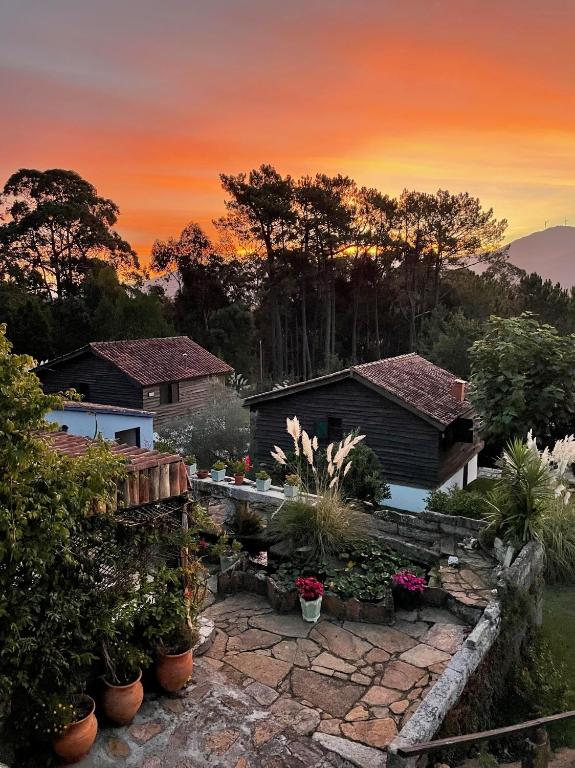 a house with a garden in front of a sunset at Shakti Rio Mino in San Bartolomé