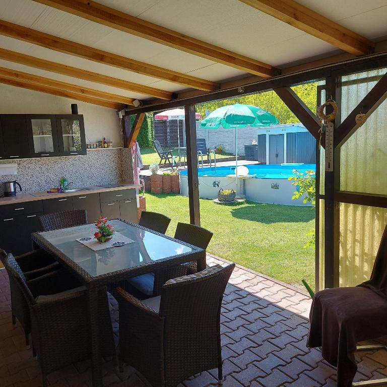 a patio with a table and chairs and an umbrella at Ferienwohnung in Spreewaldnähe in Kolkwitz