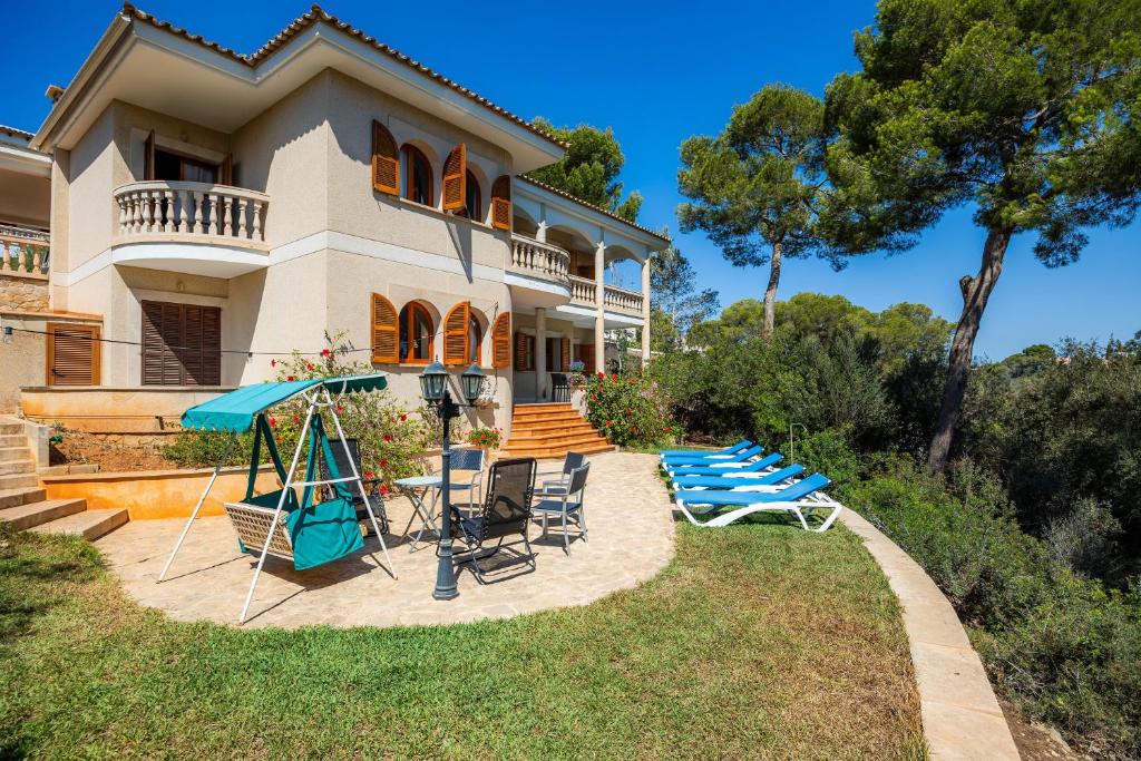 a house with chairs and umbrellas in the yard at Ca Ses Mestres in Santanyi