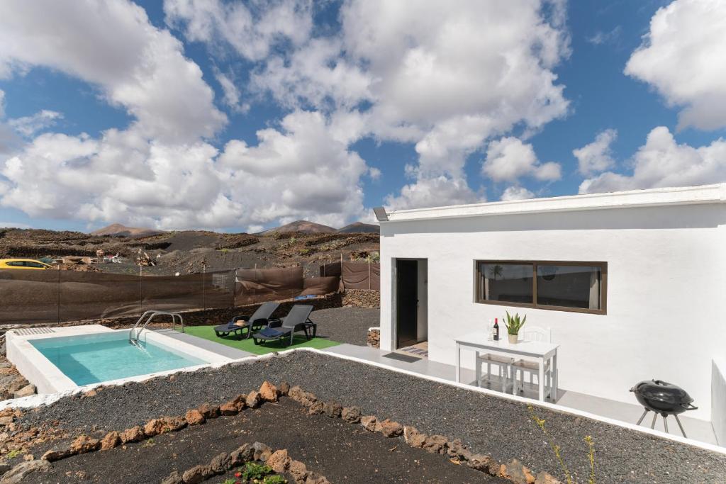 a white house with a swimming pool and a patio at Casa Jonas in Tías