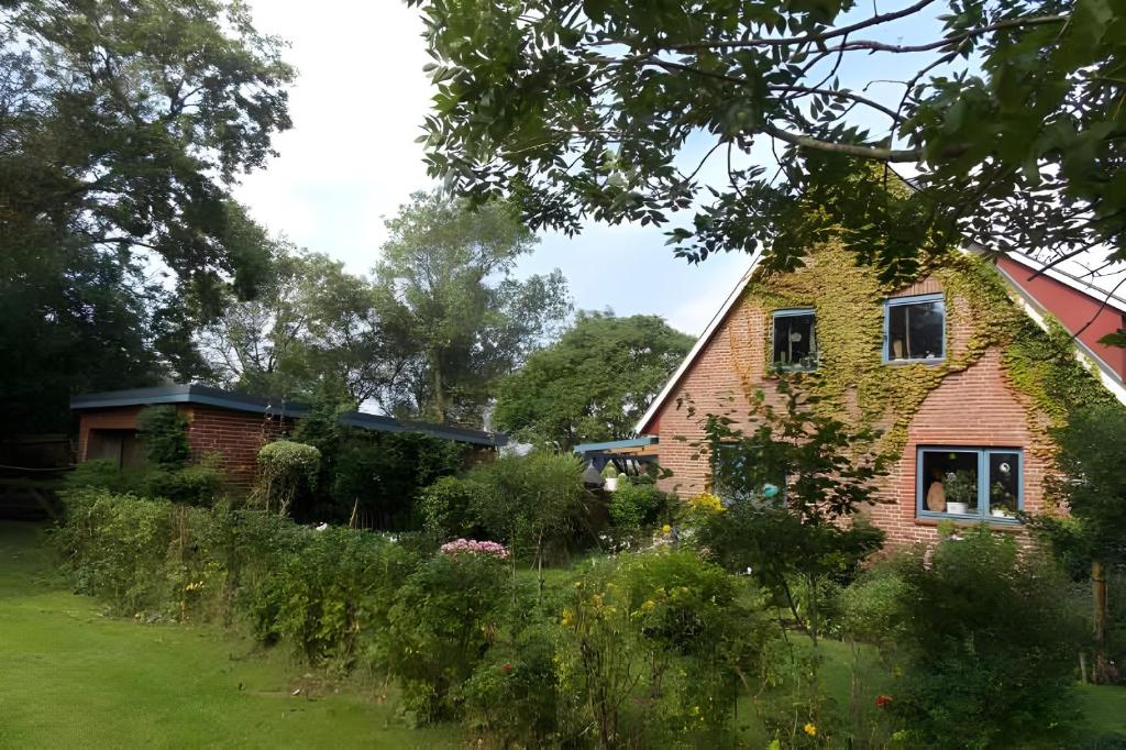a brick house with a garden in front of it at Ferienwohnung Achterndiek in Galmsbüll