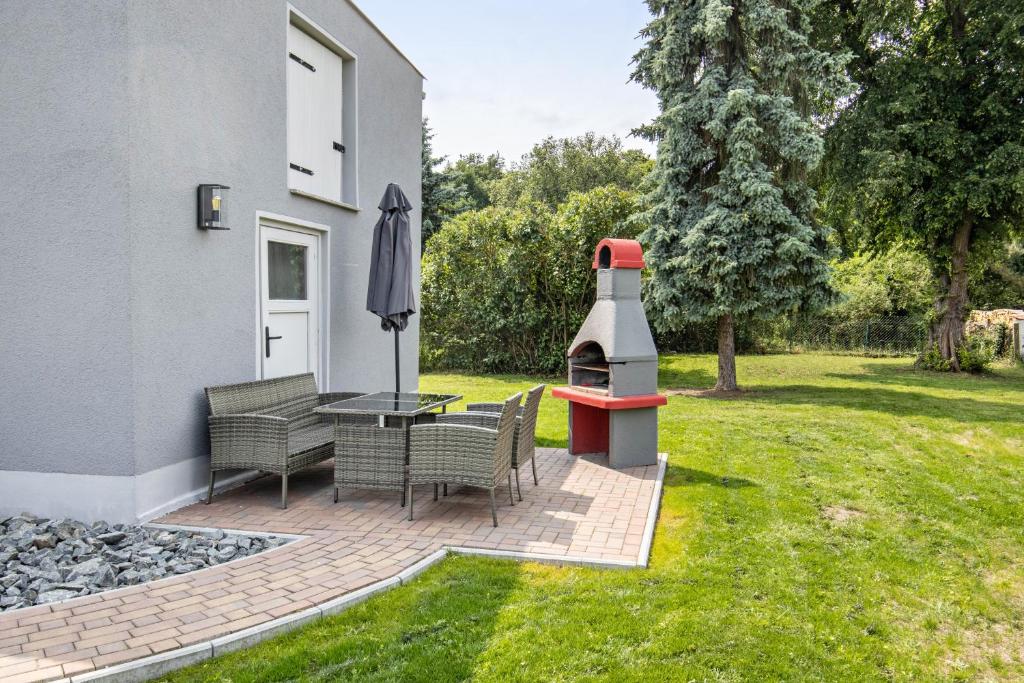 a patio with a table and chairs and a pizza oven at Ferienhaus Heidi in Bad Düben