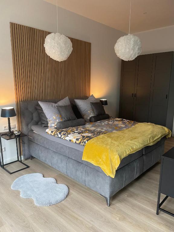 a bedroom with a bed with two lamps and two rugs at Design Apartment Flair u Komfort in Meschede