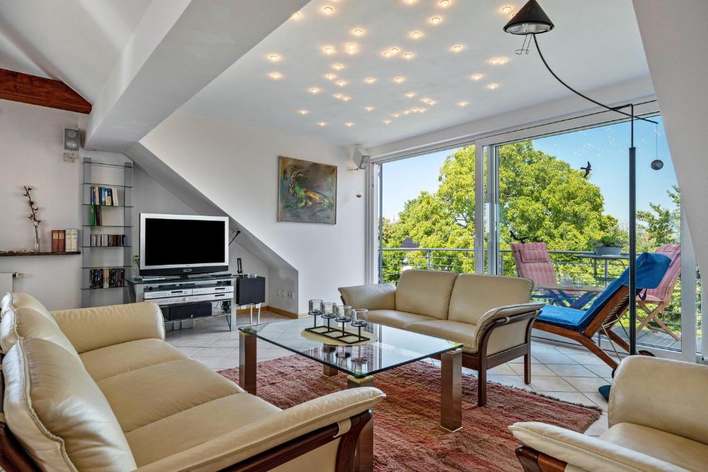 a living room with a couch and a tv and a table at Dachstübchen in Hagenburg