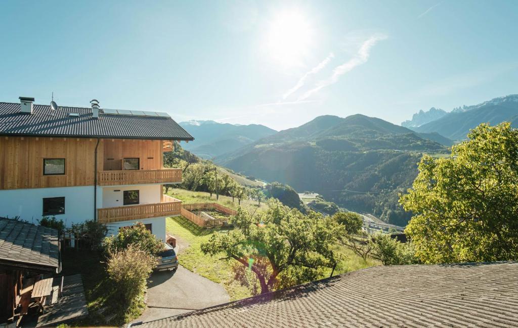 a building with a view of a valley and mountains at Oberhemberger Hof Feldthurns in Feldthurns