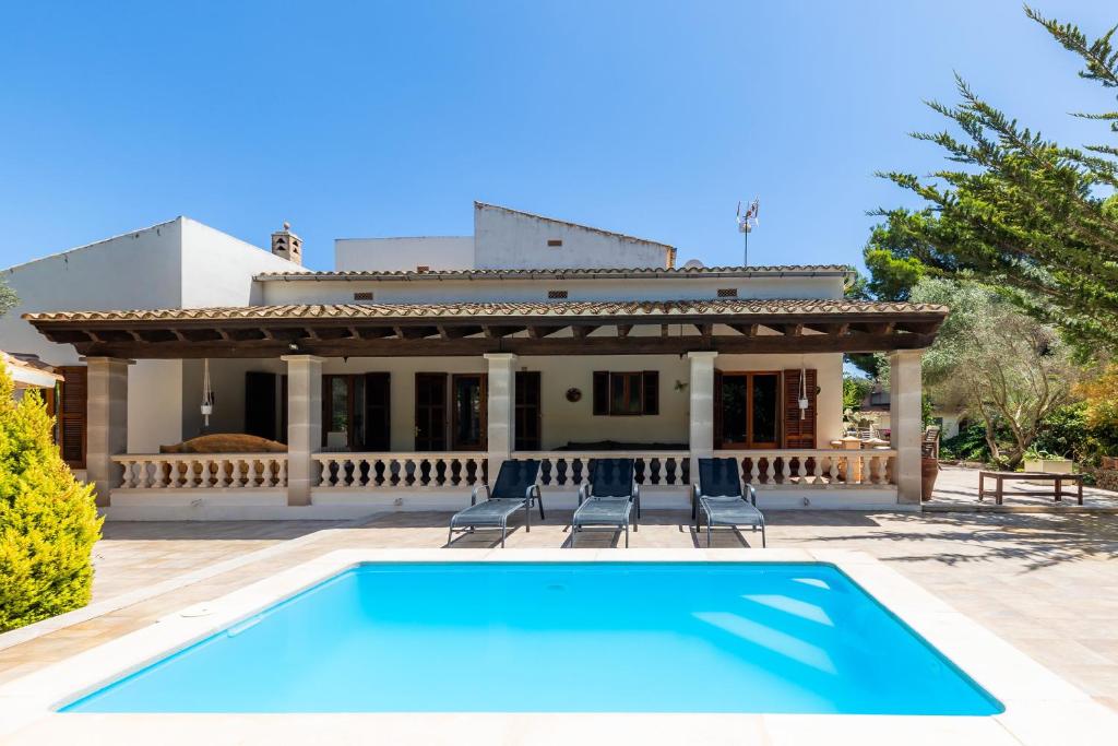 a swimming pool in front of a house at Pomeres Nou in Sa Coma