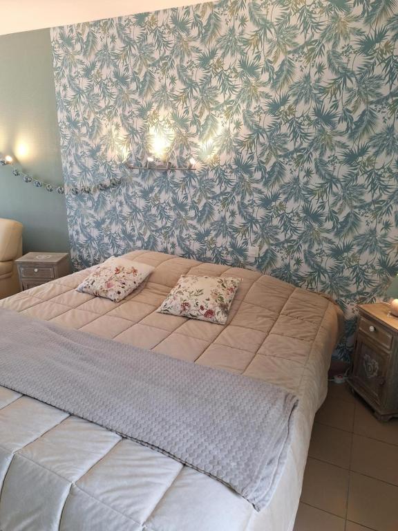 a bedroom with a bed with two pillows on it at Studio du Meslay - Fyé in Fyé