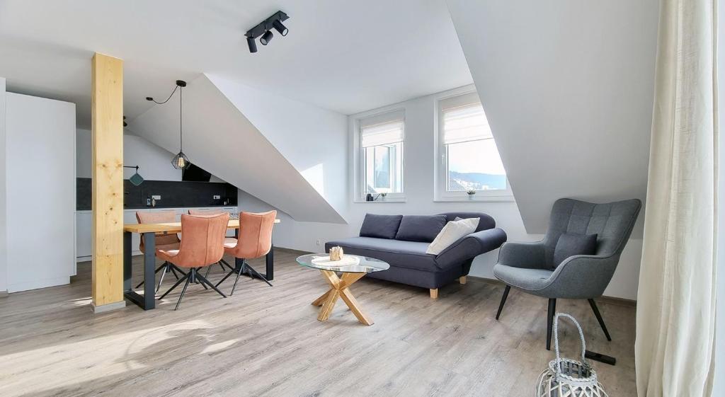 a living room with a couch and a table and chairs at Adlerhorst in Baiersbronn
