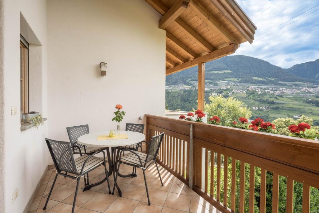 a balcony with a table and chairs and a view at Tischlerhof - Typ B mit Balkon in Tirolo
