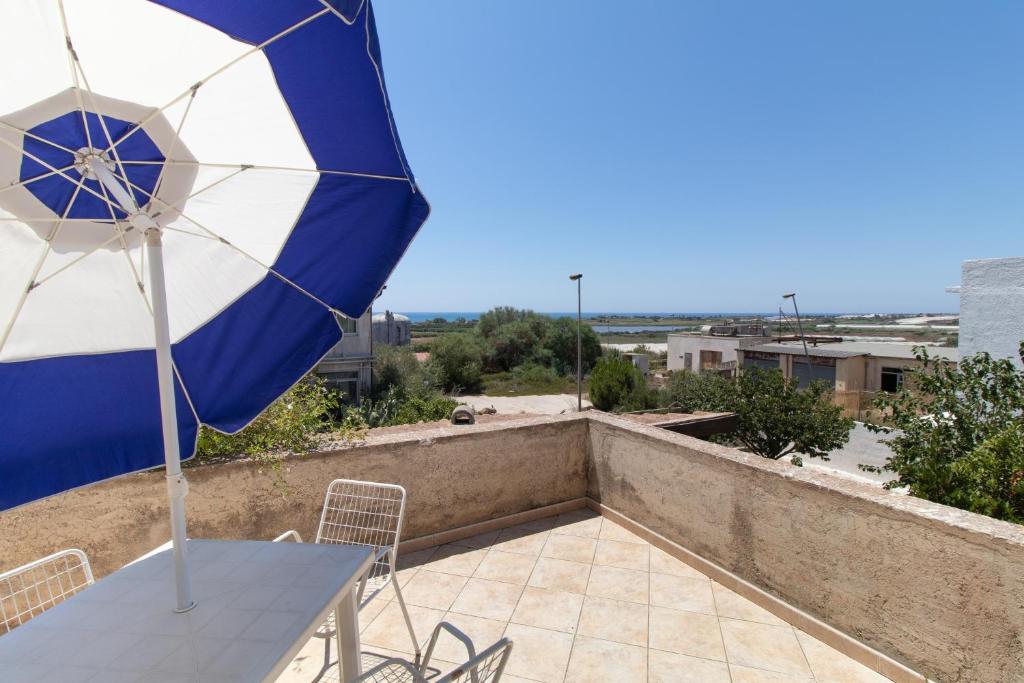 a patio with a table and an umbrella on a roof at La casa di Ulisse 2 in Ispica