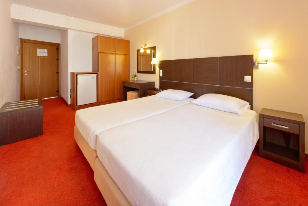 Łóżko lub łóżka w pokoju w obiekcie Akrata Beach Hotel